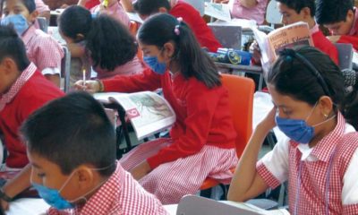 Alumnos en salón de clases usando cubrebocas