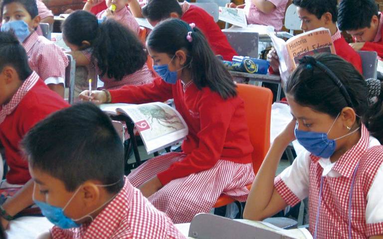 Alumnos en salón de clases usando cubrebocas